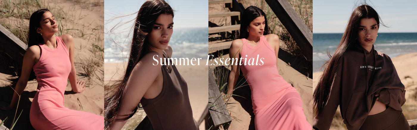 En somrig bildkollage med fyra paneler som visar en modell på stranden med havet i bakgrunden, och texten "Summer Essentials" på bannern. Hon ses i olika positioner, iklädd en rosa Hibiscus Ease Ribbed Tank Dress, en brun Macchiato Ease Ribbed Tank Dress, samt en mörkbrun Macchiato Varsity Chunky Terry Hood med matchande biker shorts.